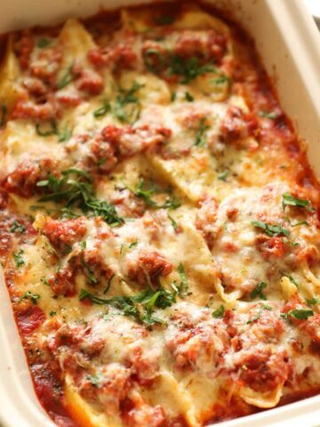 baked shells stuffed with ricotta cheese in a casserole dish