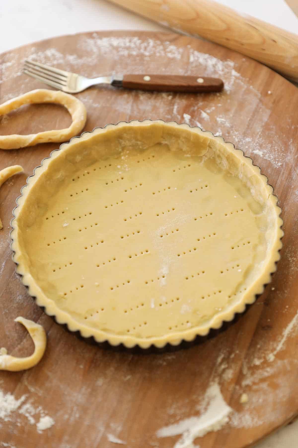 pastry dough fitted into a tart tin and pierced with a fork