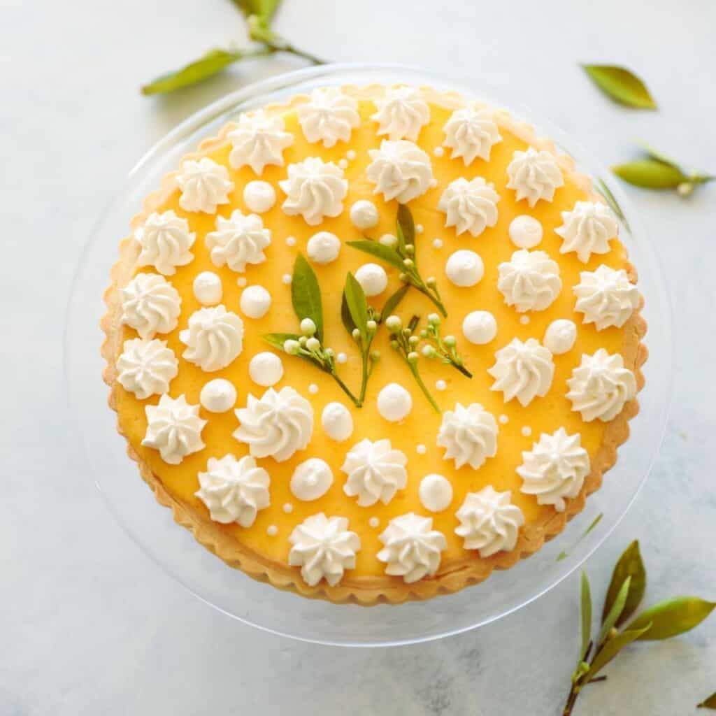 a lemon curd tart with whipped cream dollops