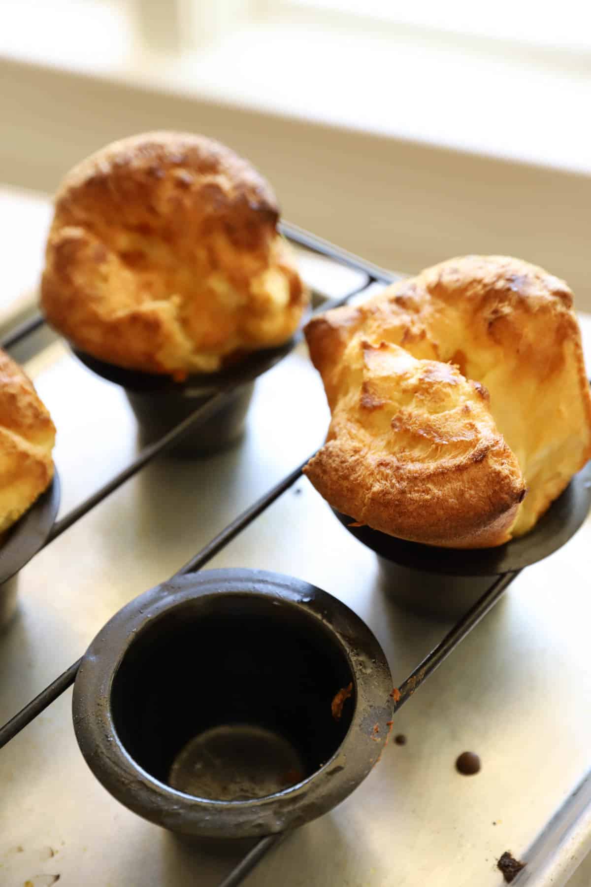 a popover pan with an empty well and one with a baked popover