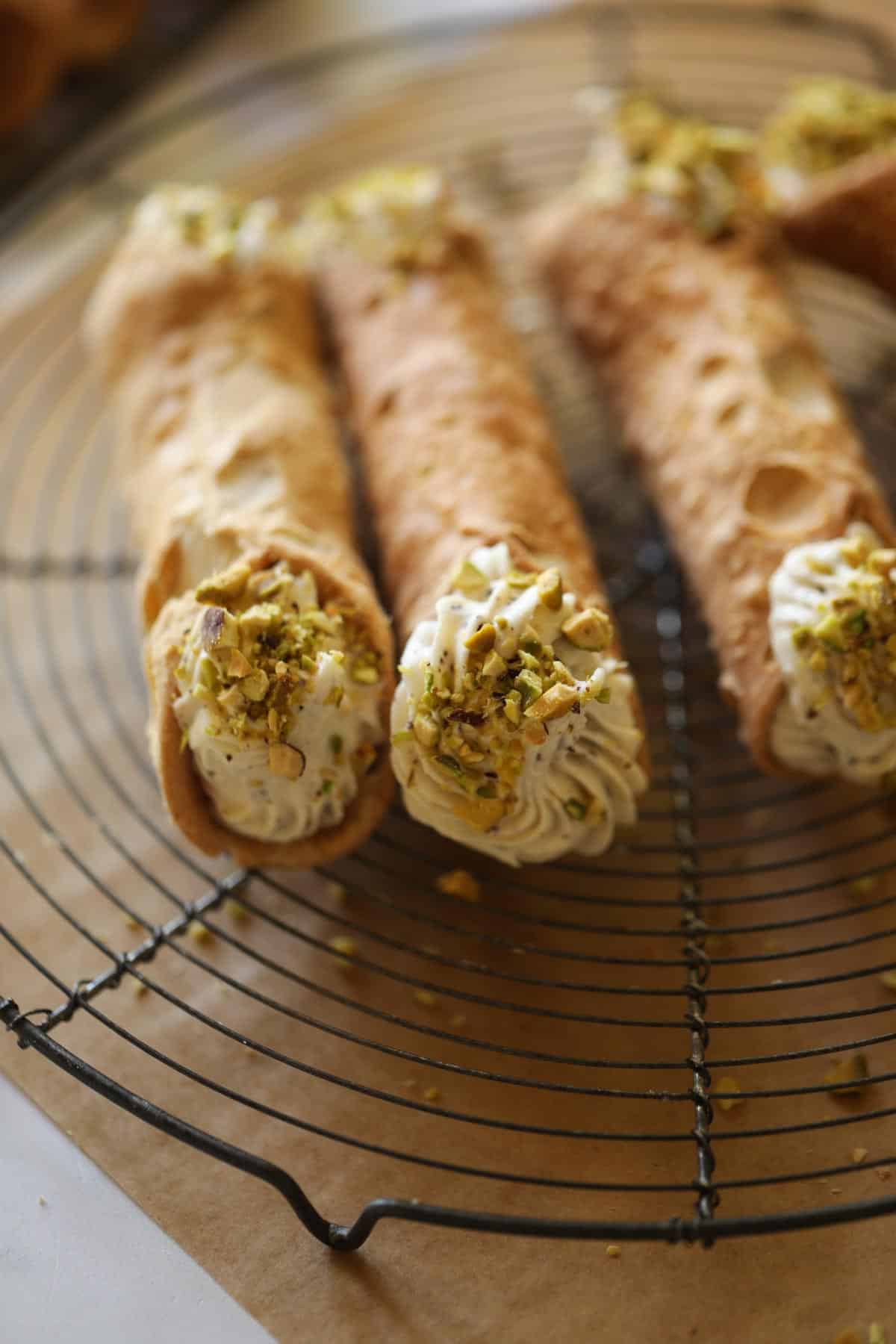 cannoli shells filled with cannoli cream and chopped pistachios