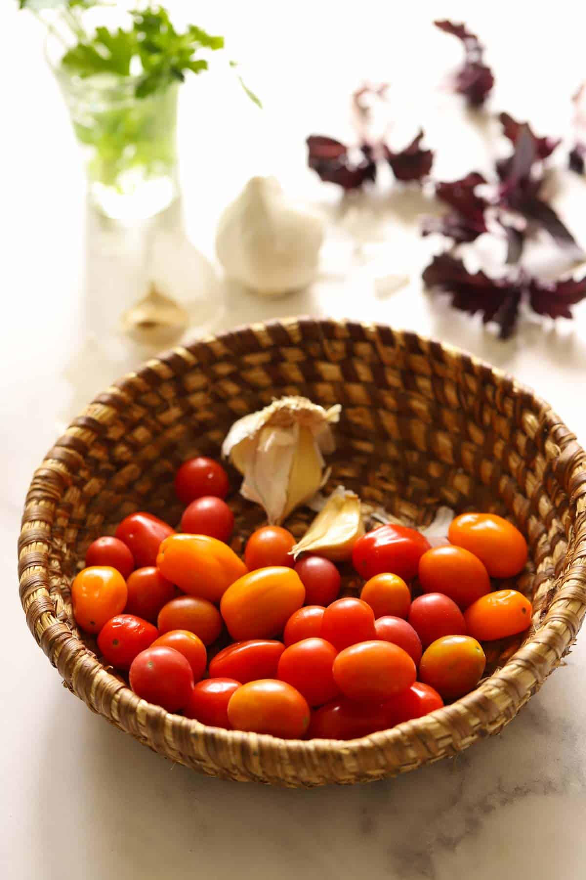 Cherry tomatoes, garlic or shallots, topped with fresh basil is a refreshing topping for grilled chicken in the warmer months