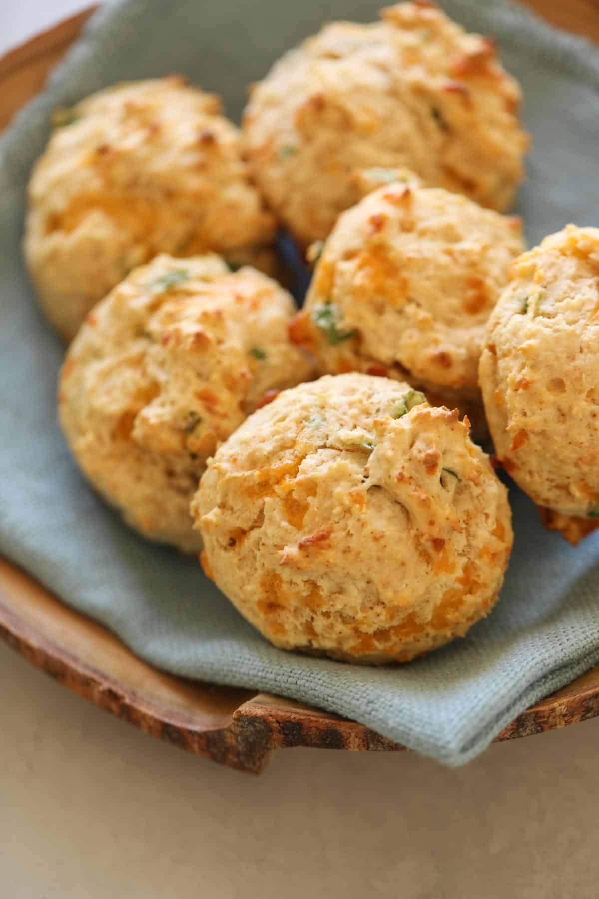 a basket of cheddar cheese drop biscuits with blue bapkin