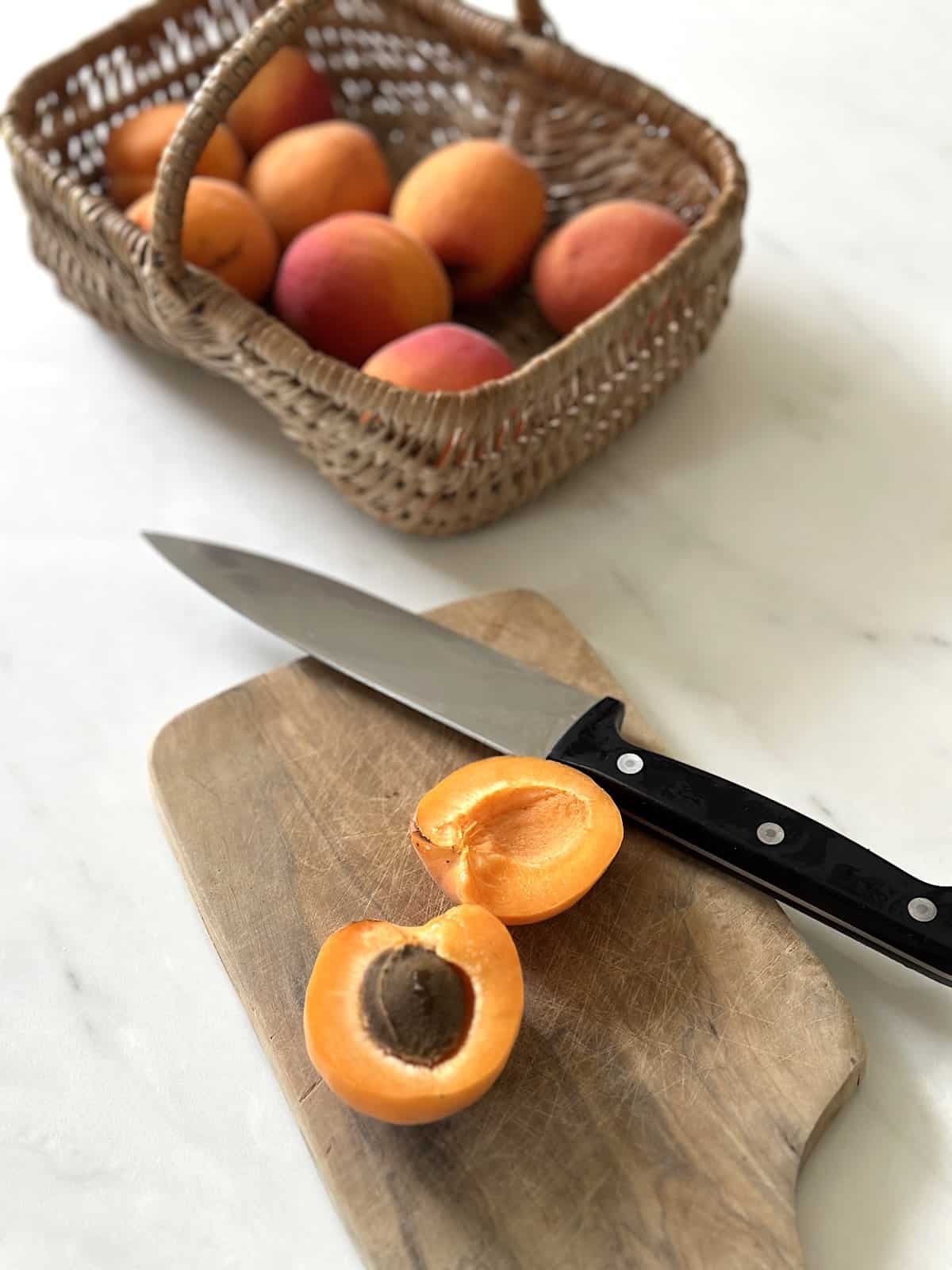 Sliced apricot on cutting board with knife