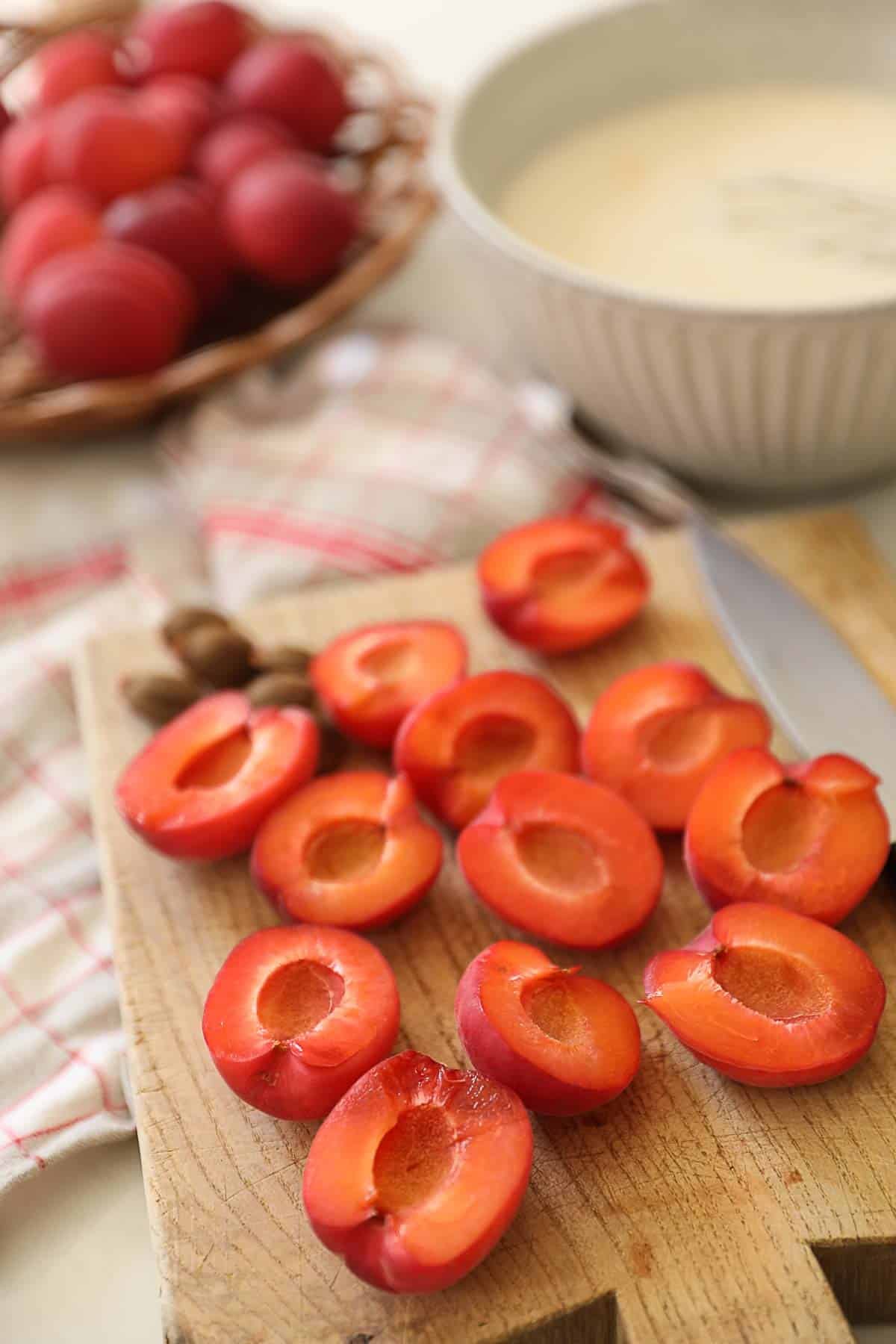 Apricots being sliced on a cutting board.