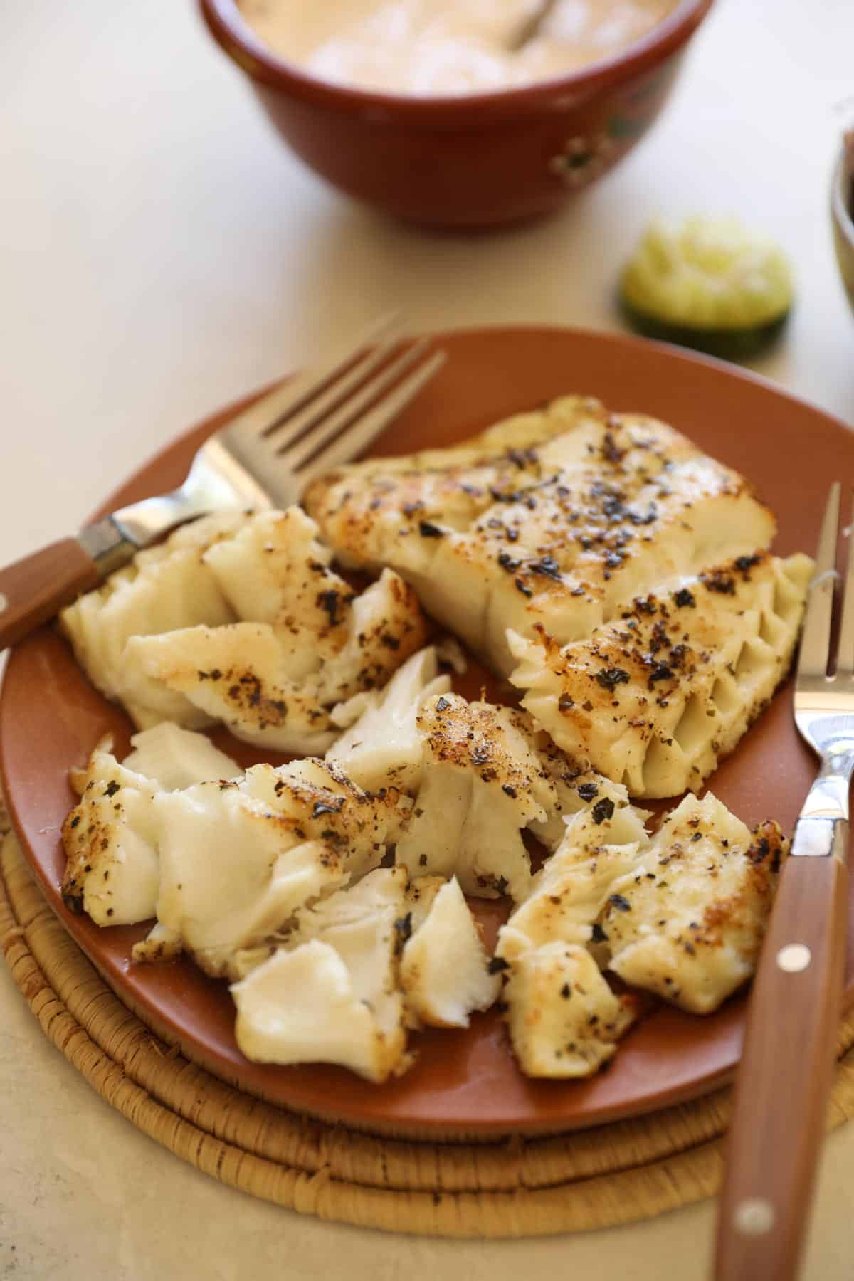 white fish chunks pulled apart with 2 forks