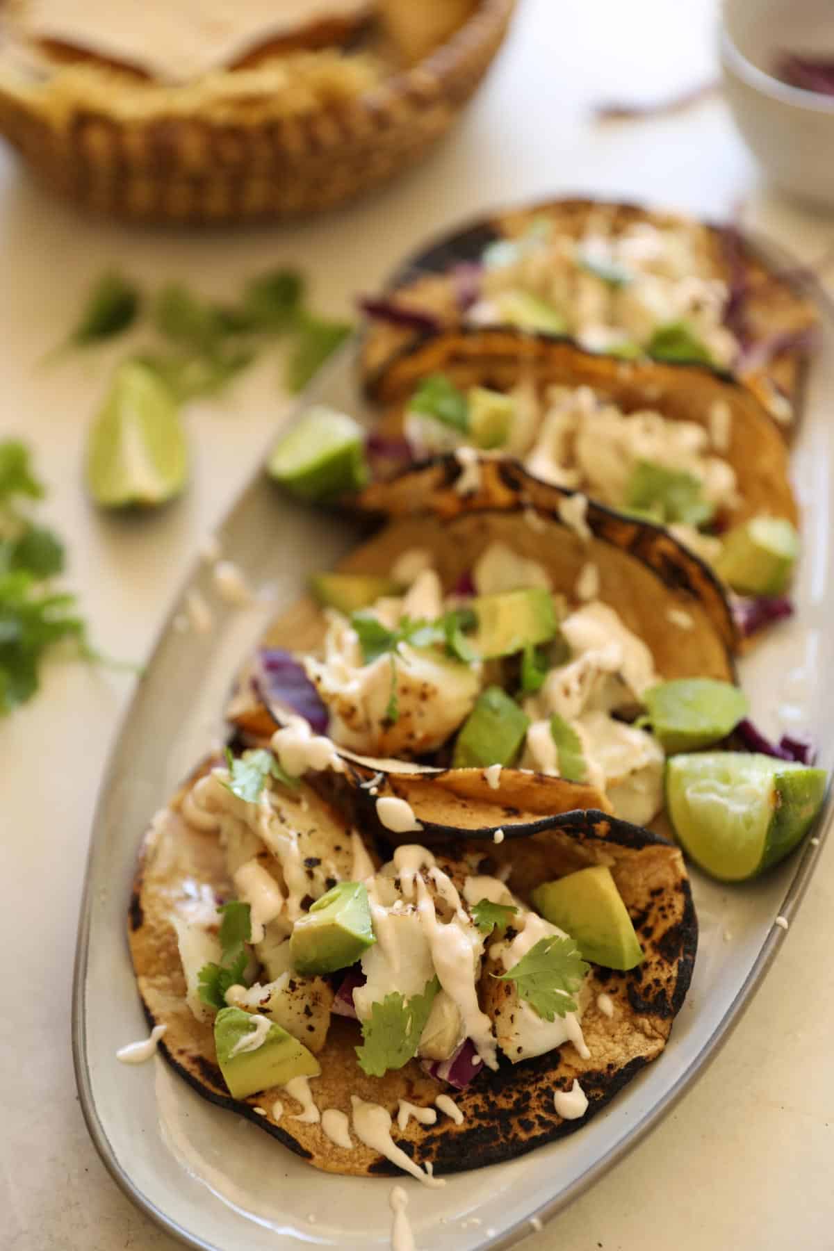 Flakey cod fish is a perfect match with spicy cream sauce, ripe avocados, cilantro and slightly charred corn tortillas