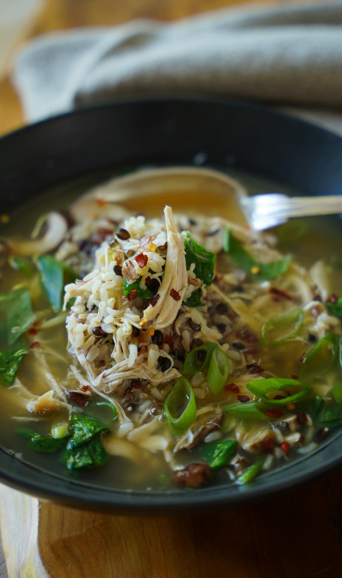 chicken and rice soup in a black bowl.