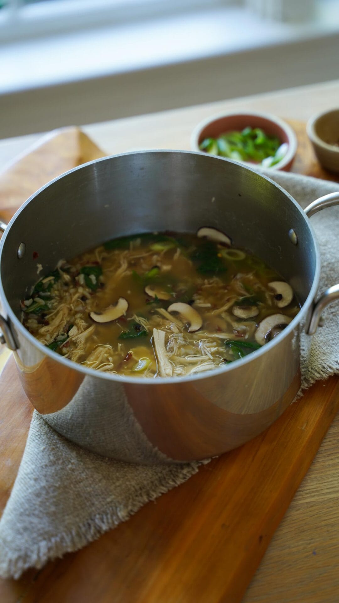 a soup pot with rotisserie chicken, mushrooms, rice and broth.