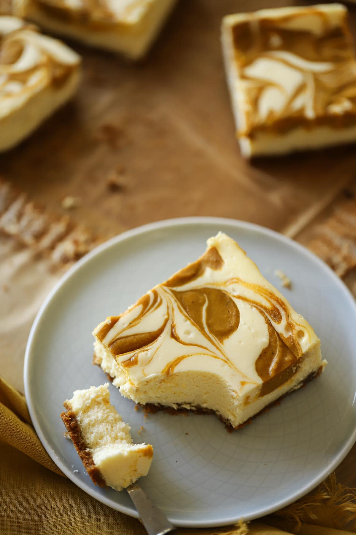 A Cheesecake pumpkin Bar with a bite taken out of it