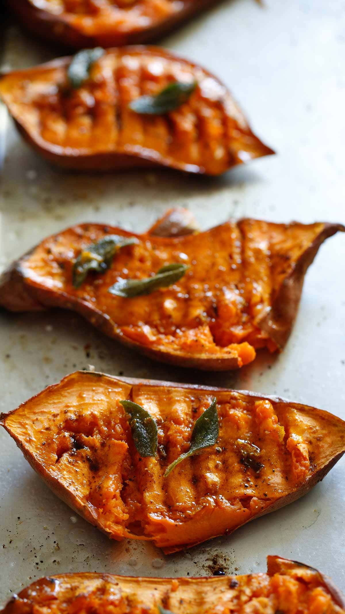 Smashed Sweet Potatoes on a Baking Tray with crispy sage