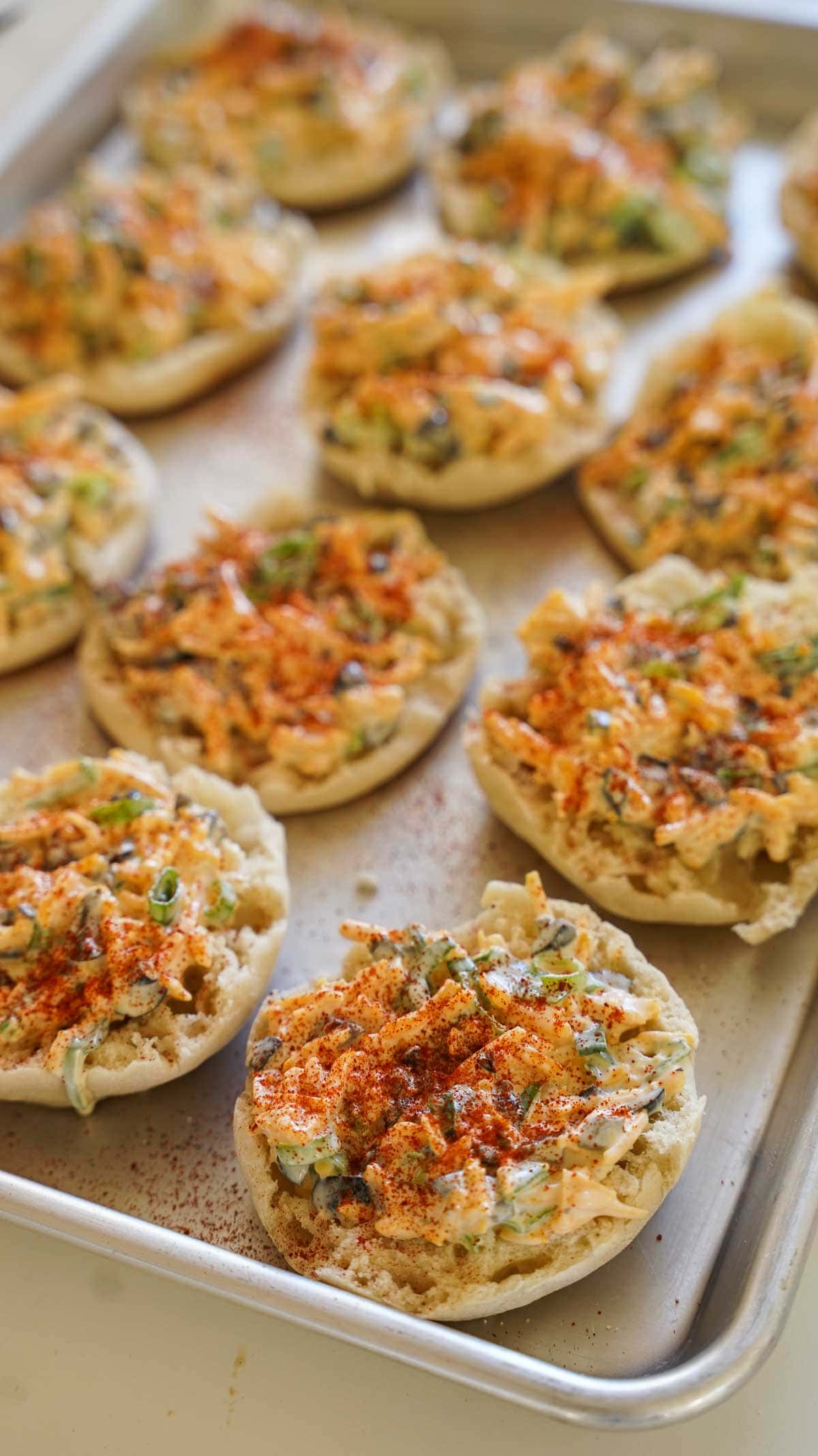 Spreading cheese mixture on English muffins