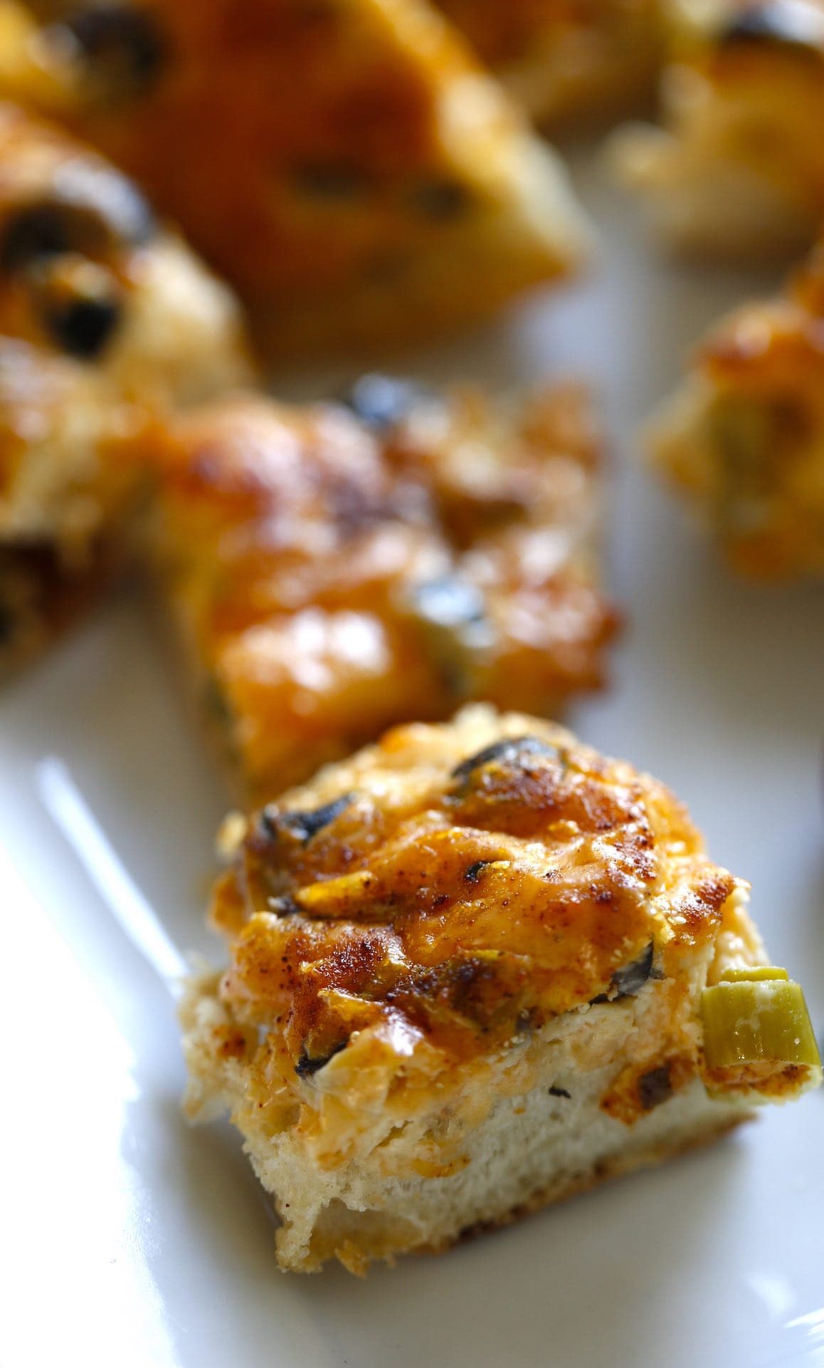 a close up of an English muffin appetizer on a white platter