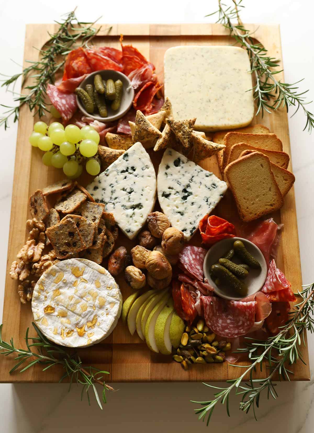 a board with cheese, crackers and charcuterie on it