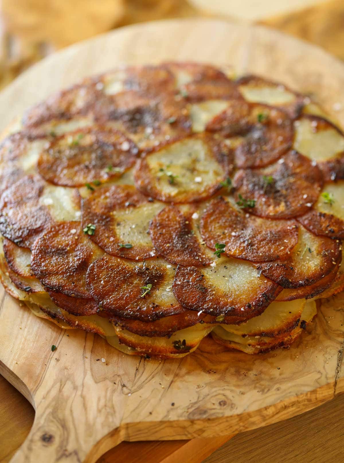 Anna Potatoes on a board with sea salt and thyme