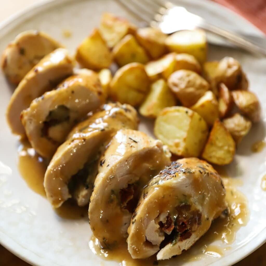 Stuffed Chicken Breasts on a plate with potatoes.