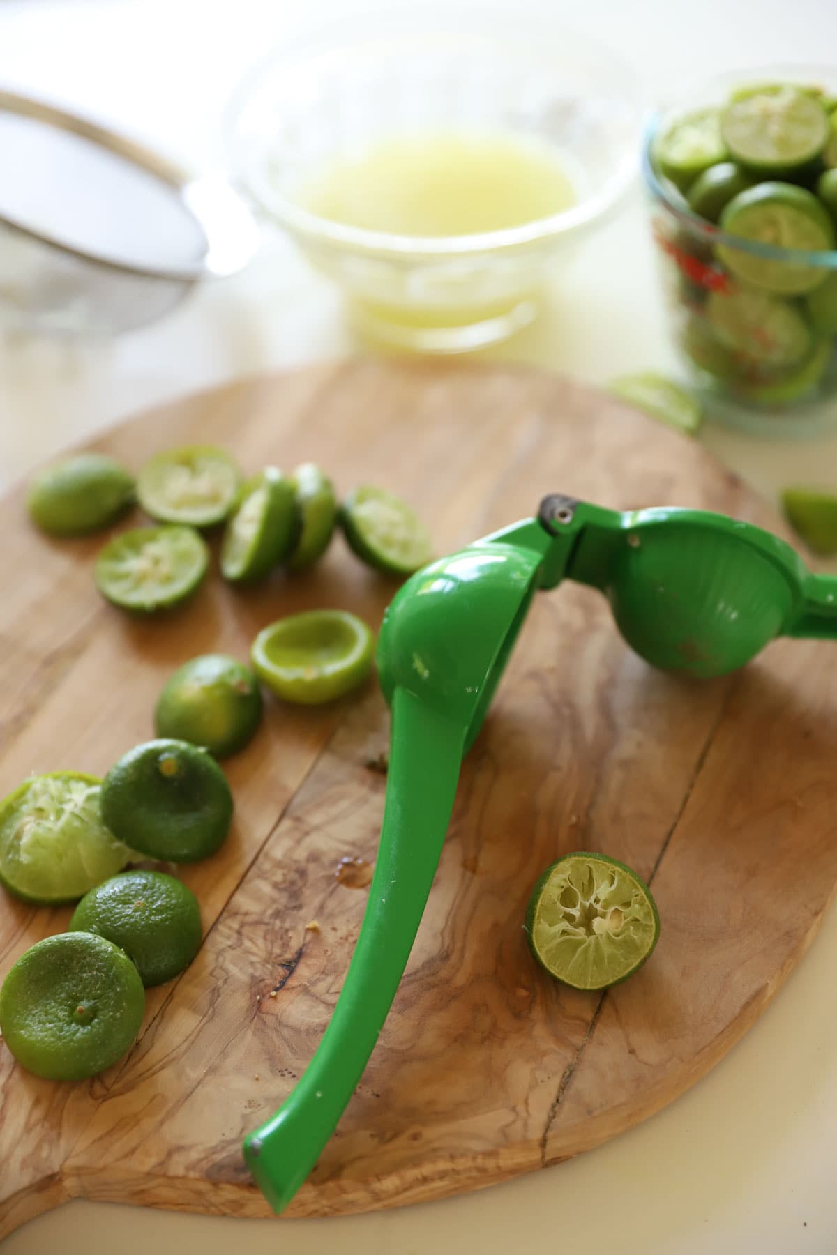 key limes being squeezer with a lime squeezer.