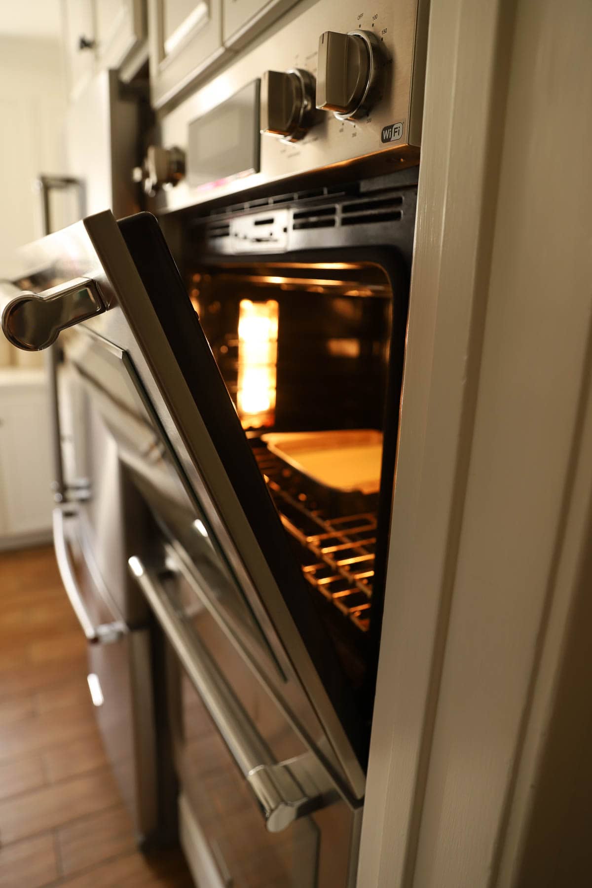 oven door open with cheesecake cooling inside.