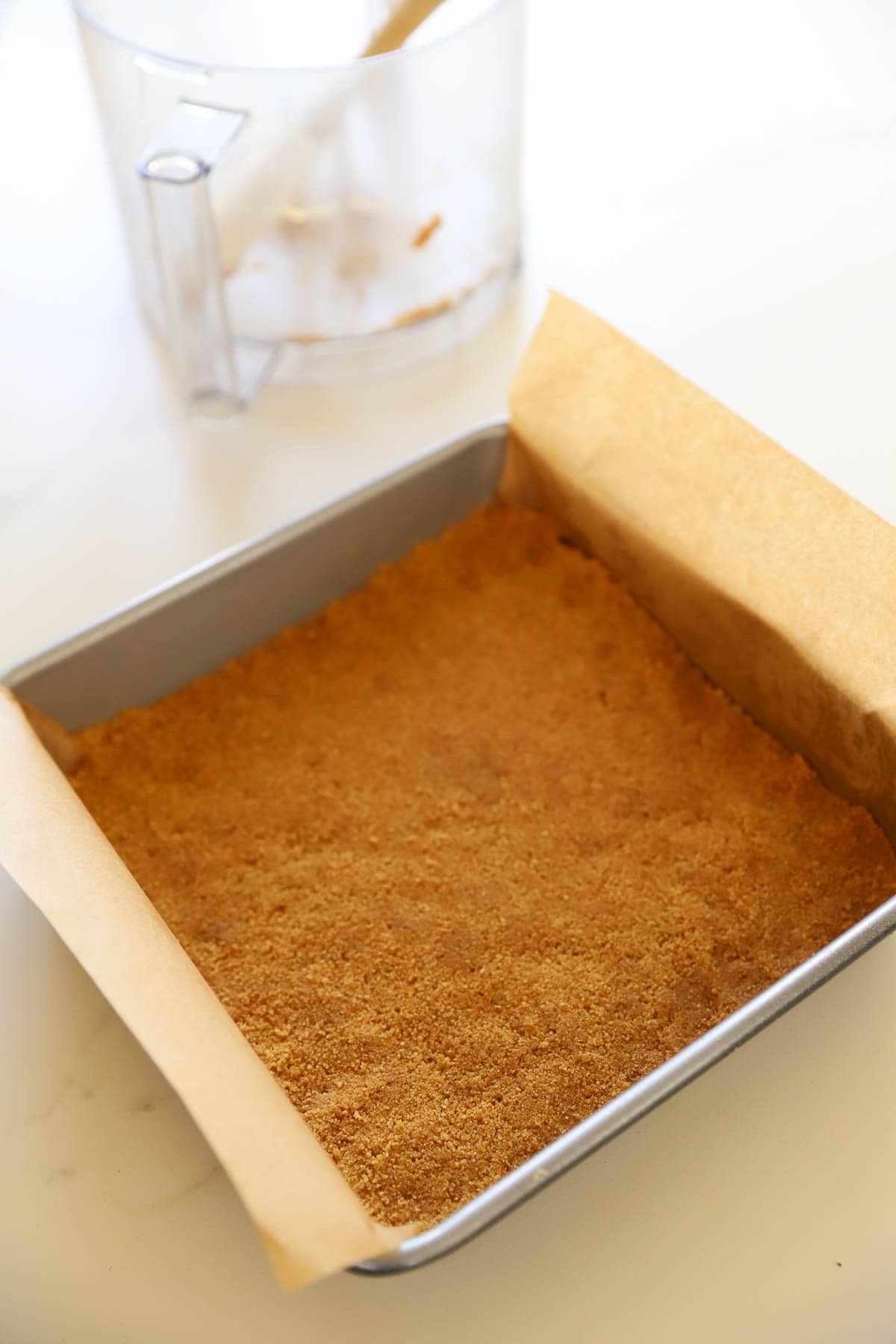 a brownie pan filled with graham cracker crumbs.