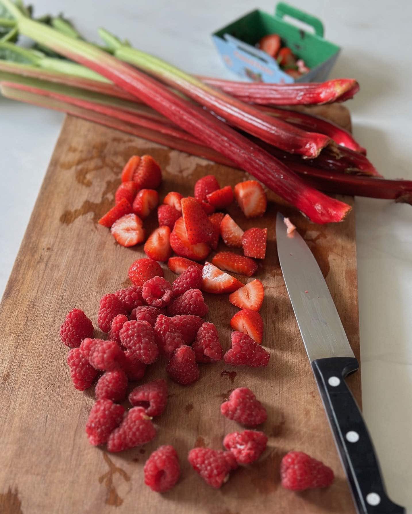 Rhubarb, raspberries and strawberries on a cutting board