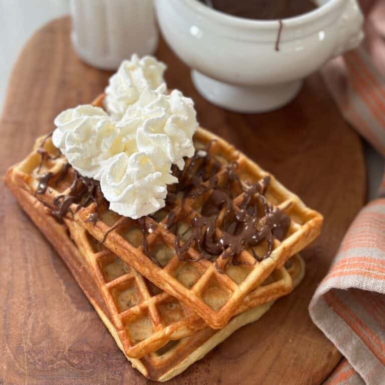 dessert waffles on a board with Nutella and Whipped Cream