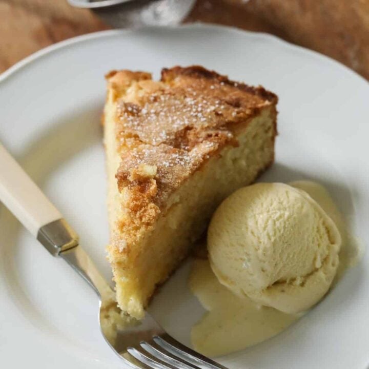 A slice of cake on a plate with a scoop of Ice Cream