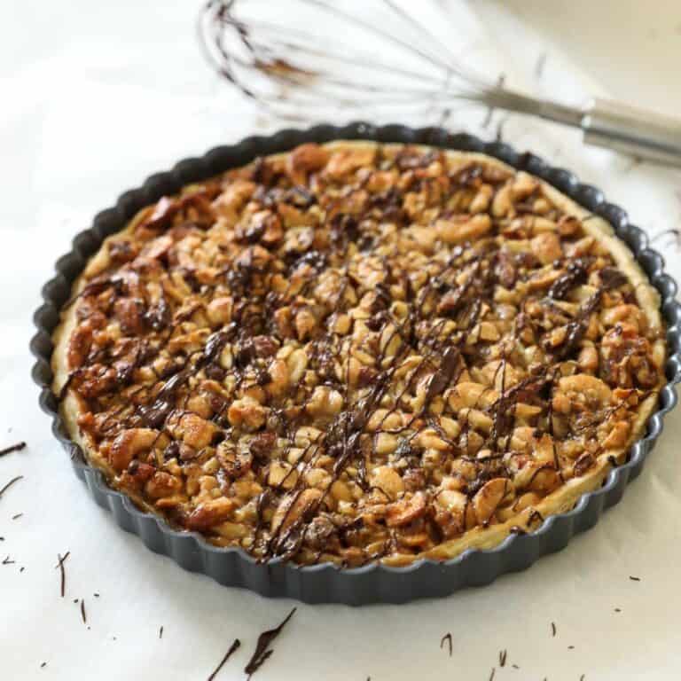 a nut tart covered with chocolate drizzle