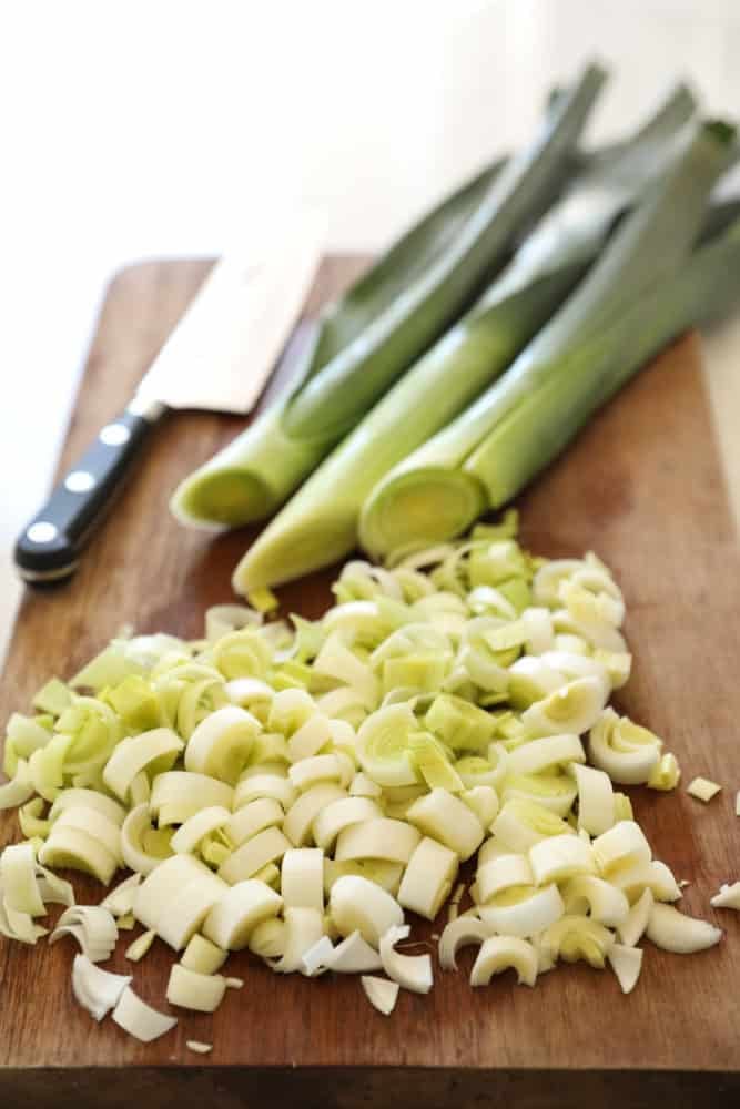 Leeks on a cutting board chopped into half moons.