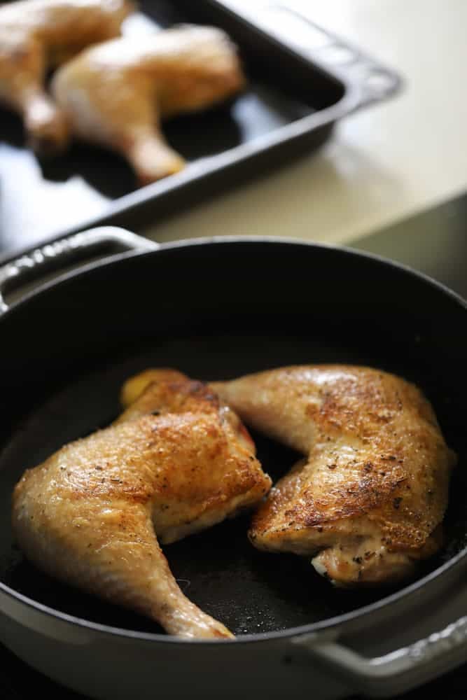 Chicken legs searing in a pan