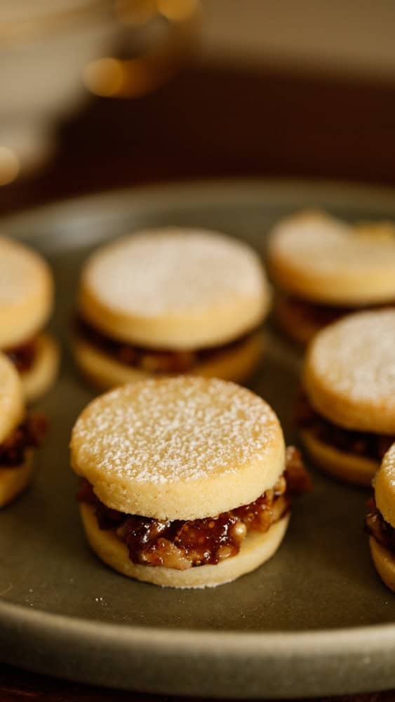 A sandwiched cookie with fig filling and dusted powdered sugar.