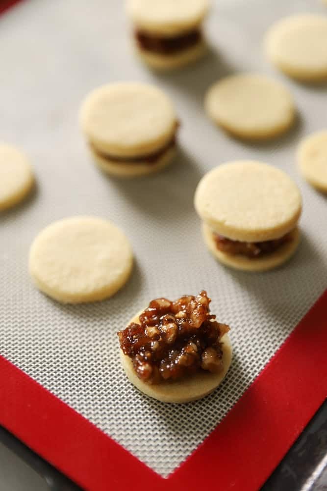 A fig and walnut filling spooned on top of a buttery cookie.