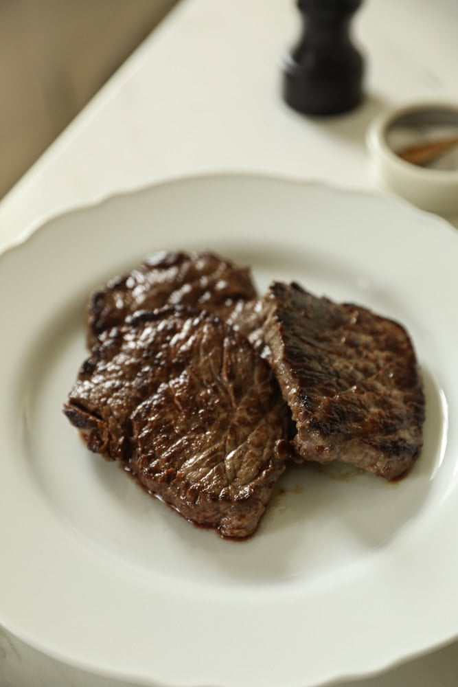 Seared steak on a plate resting.