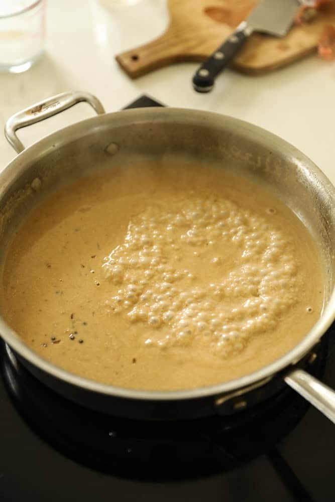 peppercorn sauce simmering in a deep skillet. 