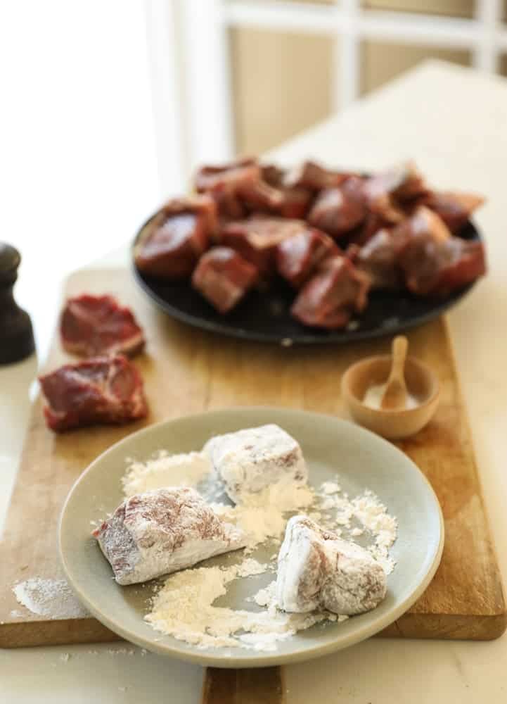 Stew meat being dredged in flour