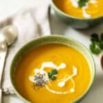 Carrot GInger Soup in a green bowl with chia seeds and coconut milk.