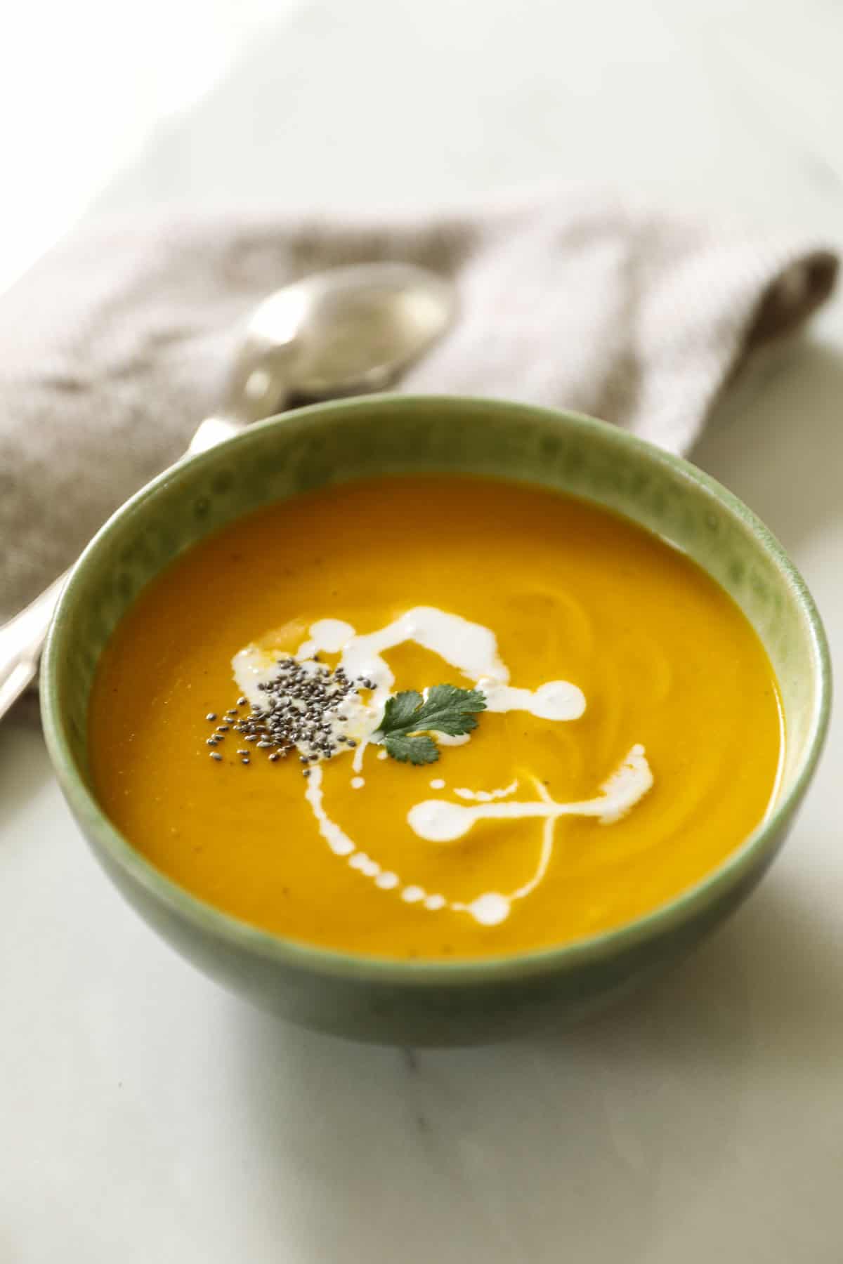 A close up of carrot ginger soup with coconut milk.