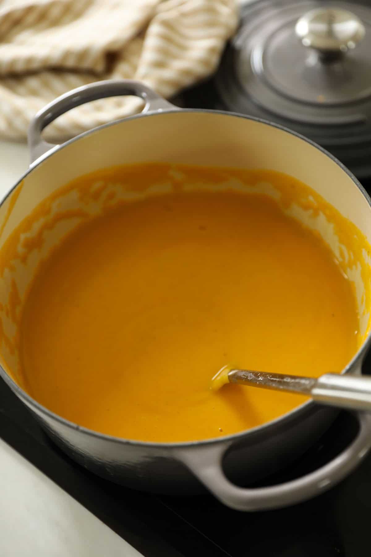 Soup in a large Dutch oven with a ladel.